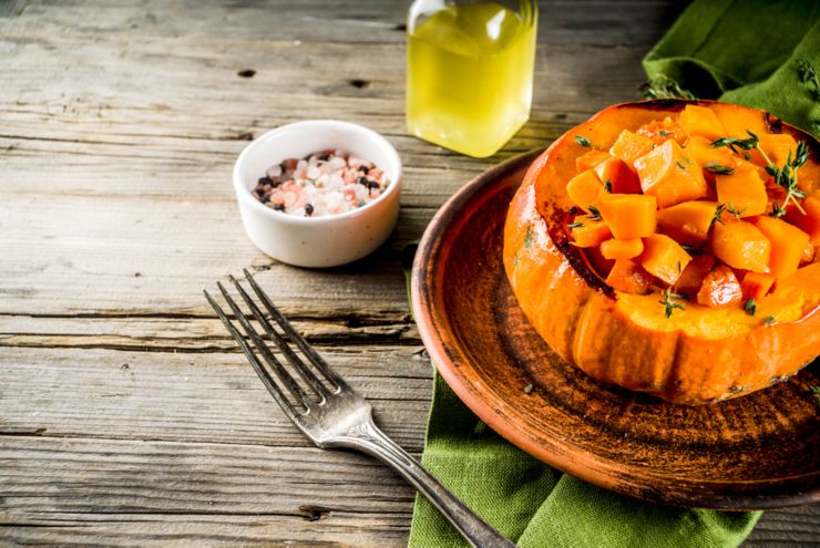 Traditional autumn home food, recipes ideas for Thanksgiving, Grilled baked stuffed pumpkin with honey and thyme, on an old wooden background, with spices copy space