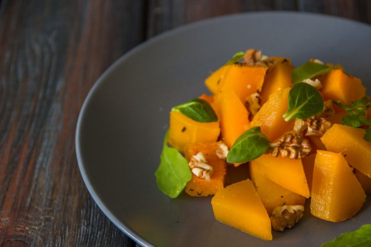 Salad with pumpkin walnuts and green leaves.