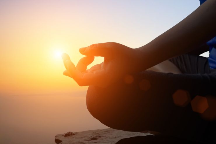 Young women meditate while doing yoga meditation, spiritual mental health practice with silhouette of lotus pose having peaceful mind relaxation on mountain outdoor with sunset golden heavenly sky. Yoga class. Young couple are meditating and doing yoga.