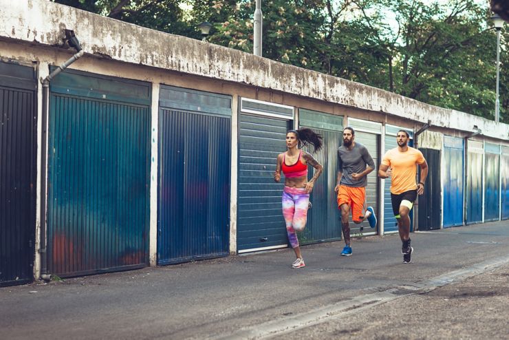 Sportswoman and two sportsmen jogging together.