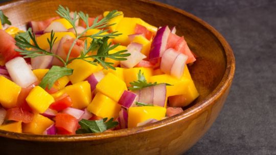 Mango Salsa on wooden bowl, side view