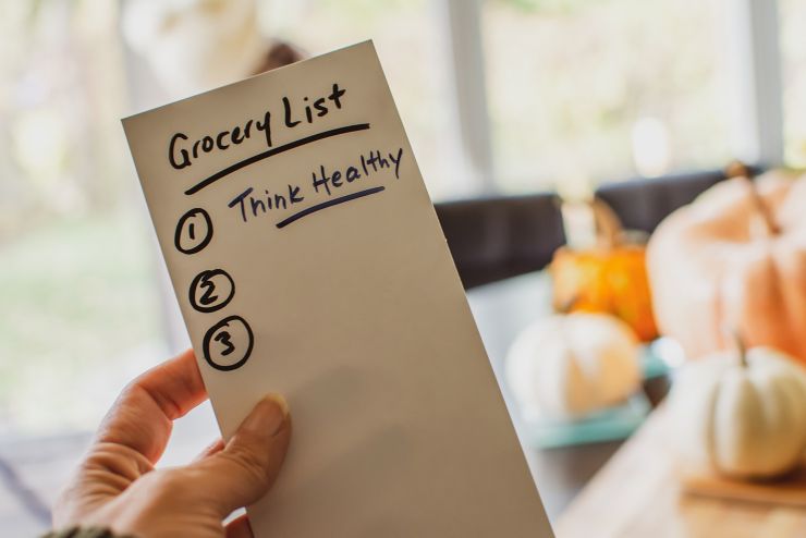 Grocery list with note to self for healthy eating new year resolution getting in shape over the Thanksgiving and Christmas holidays and eating well grocery list written with motivation message think healthy, and numbers for steps to making good food choic