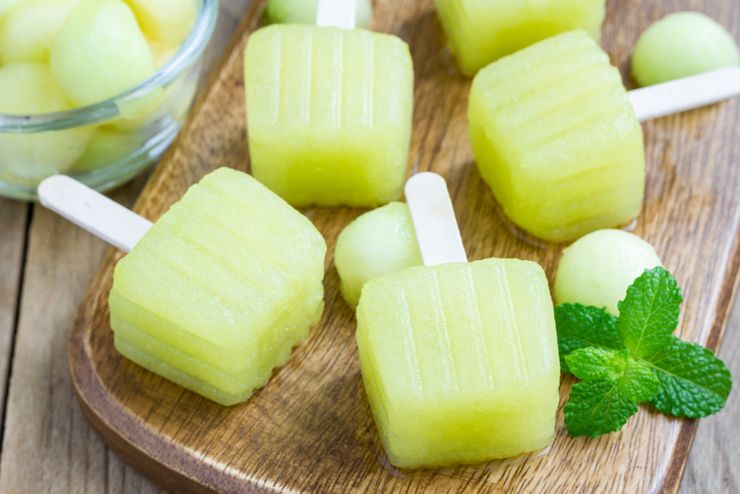 Homemade melon popsicles on a wooden background closeup