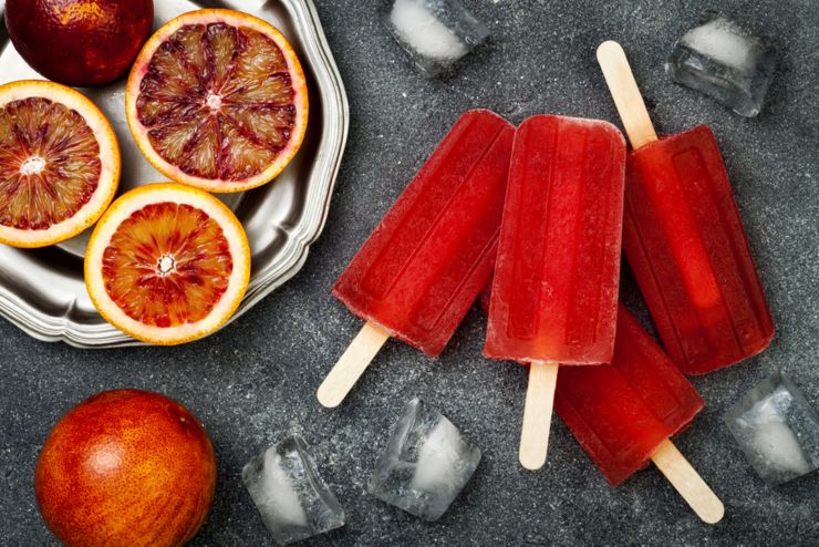 Homemade frozen blood orange natural juice alcoholic popsicles - paletas - ice pops. Overhead flat lay top view