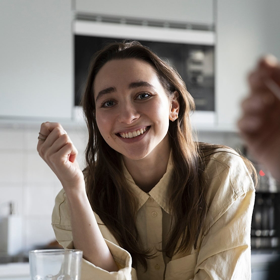 Portrait of smiling woman having breakfast at table