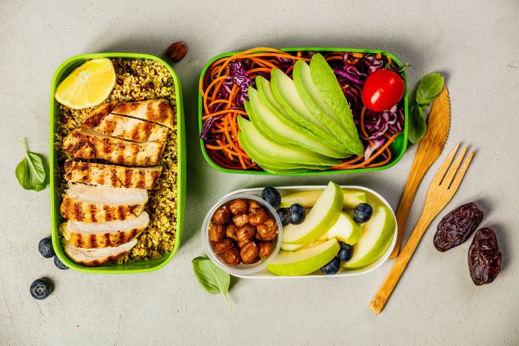 Healthy meal prep containers: Couscous with grilled chicken breast, salad, avocado, berry, apple, nuts and dry dates. Keto, ketogenic diet, low carb, healthy food concept. Top view