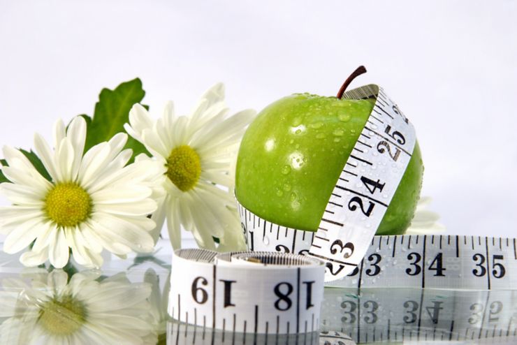 Measurement tape wrapped around green apple/Concept for health, diet