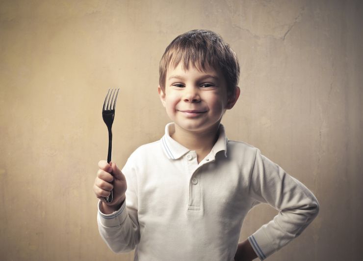 Smiling child holding a fork
