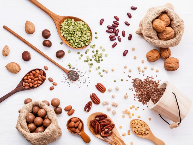 Various legumes and different kinds of nuts walnuts kernels ,hazelnuts, almond kernels,brown pinto ,soy beans ,flax seeds ,chia ,red kidney beans and pecan set up on white wooden table.; Shutterstock ID 1042425994; purchase_order: UK BLOG; job: ; client: UK Marketing; other: 