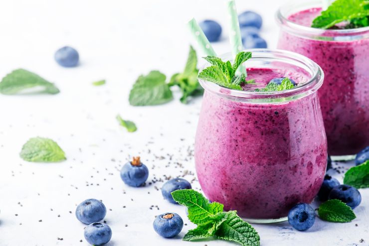 Purple homemade yogurt or smoothie with blueberries, chia seeds and mint leaves in glass jars on gray background, selective focus; Shutterstock ID 1217515378; purchase_order: UK BLOG; job: ; client: UK Marketing; other: 