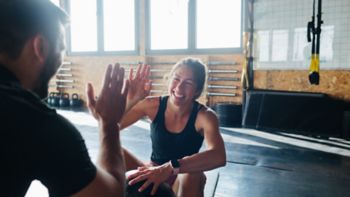 Man and woman talking and resting between workout series in gym