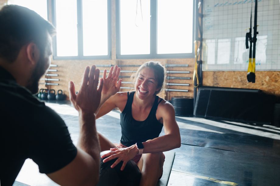Man and woman talking and resting between workout series in gym