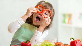 kid girl having fun with food vegetables at kitchen; Shutterstock ID 253429321