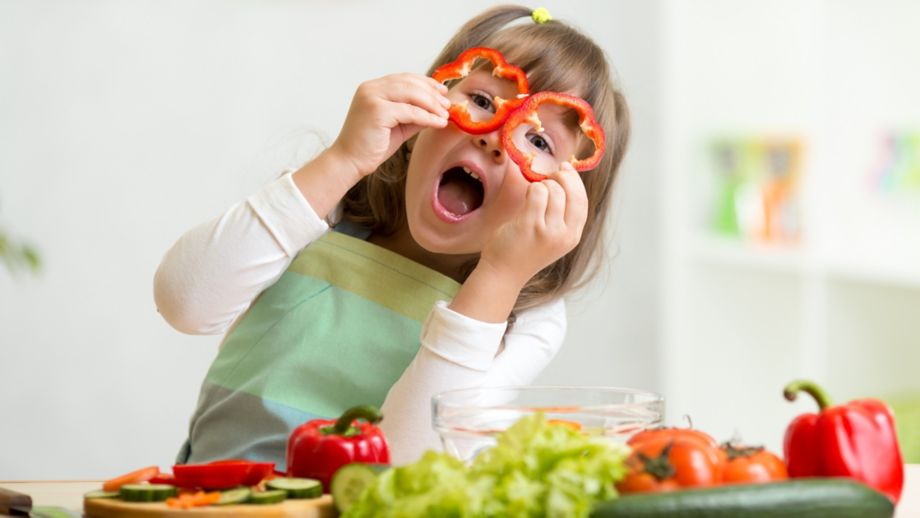 kid girl having fun with food vegetables at kitchen; Shutterstock ID 253429321