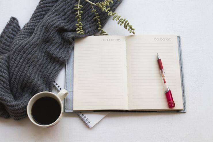 notebook planner for business work with hot coffee and knitting wool in winter season at office desk