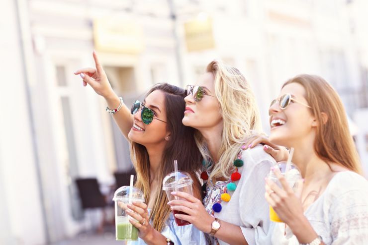 Happy girl friends hanging out in the city in summer