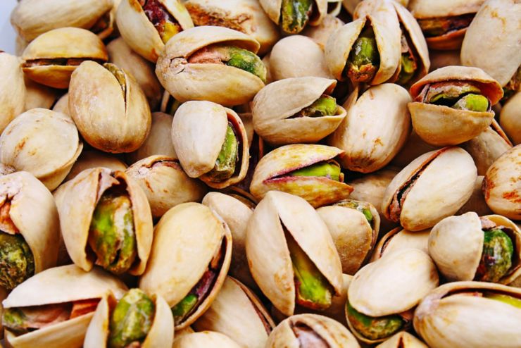 Pistachio texture. Nuts. Green fresh pistachios as texture. Roasted salted pistachio nuts healthy delicious food studio photo. Pattern.