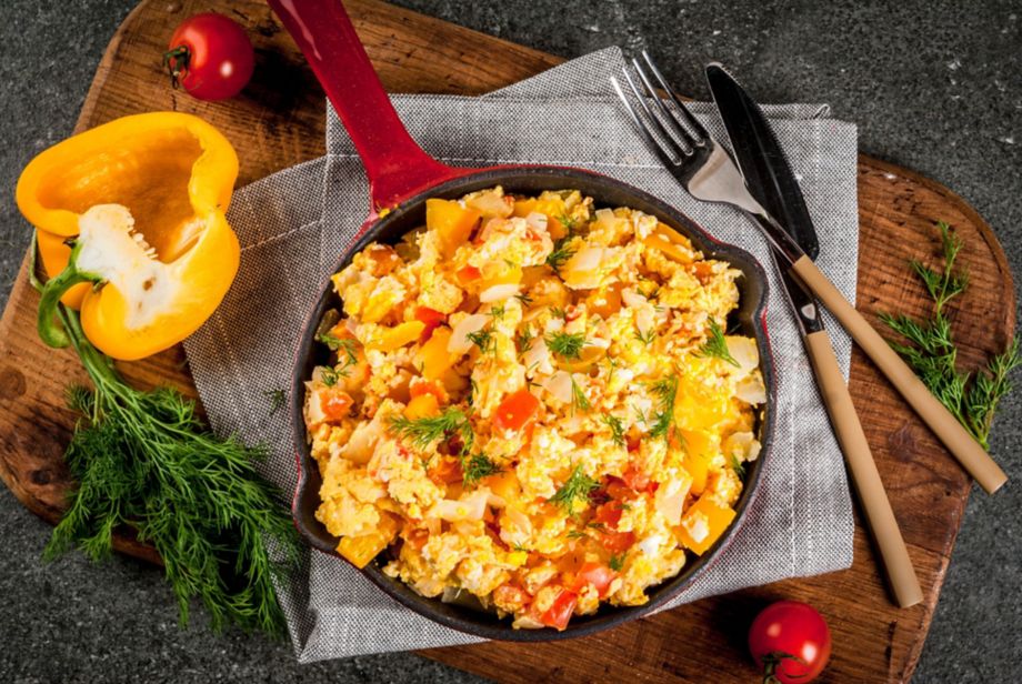 Mexican food recipes, Revoltillo de Huevos, Scrambled Eggs a la Dominicana, in portioned skillet, on dark stone table,copy space top view