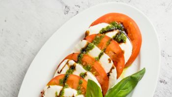caprese with tomato slices and herbs served with pesto, Italian caprese with tomato, herbs and pesto